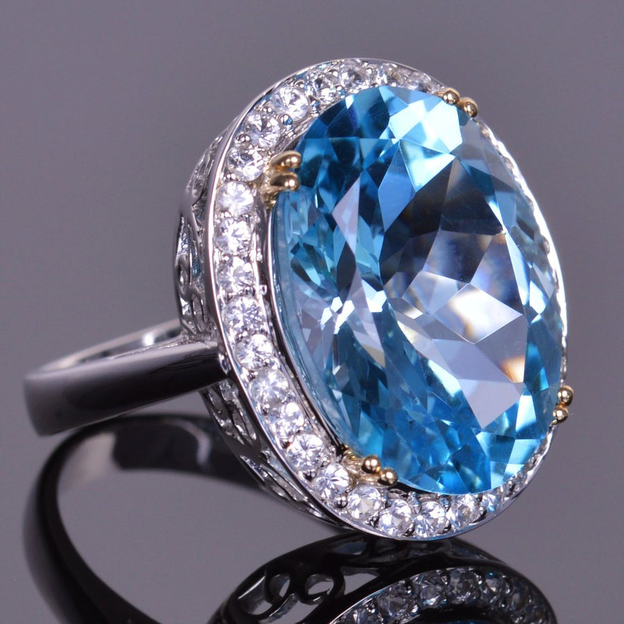 oval blue topaz ring with white sapphire halo in white gold