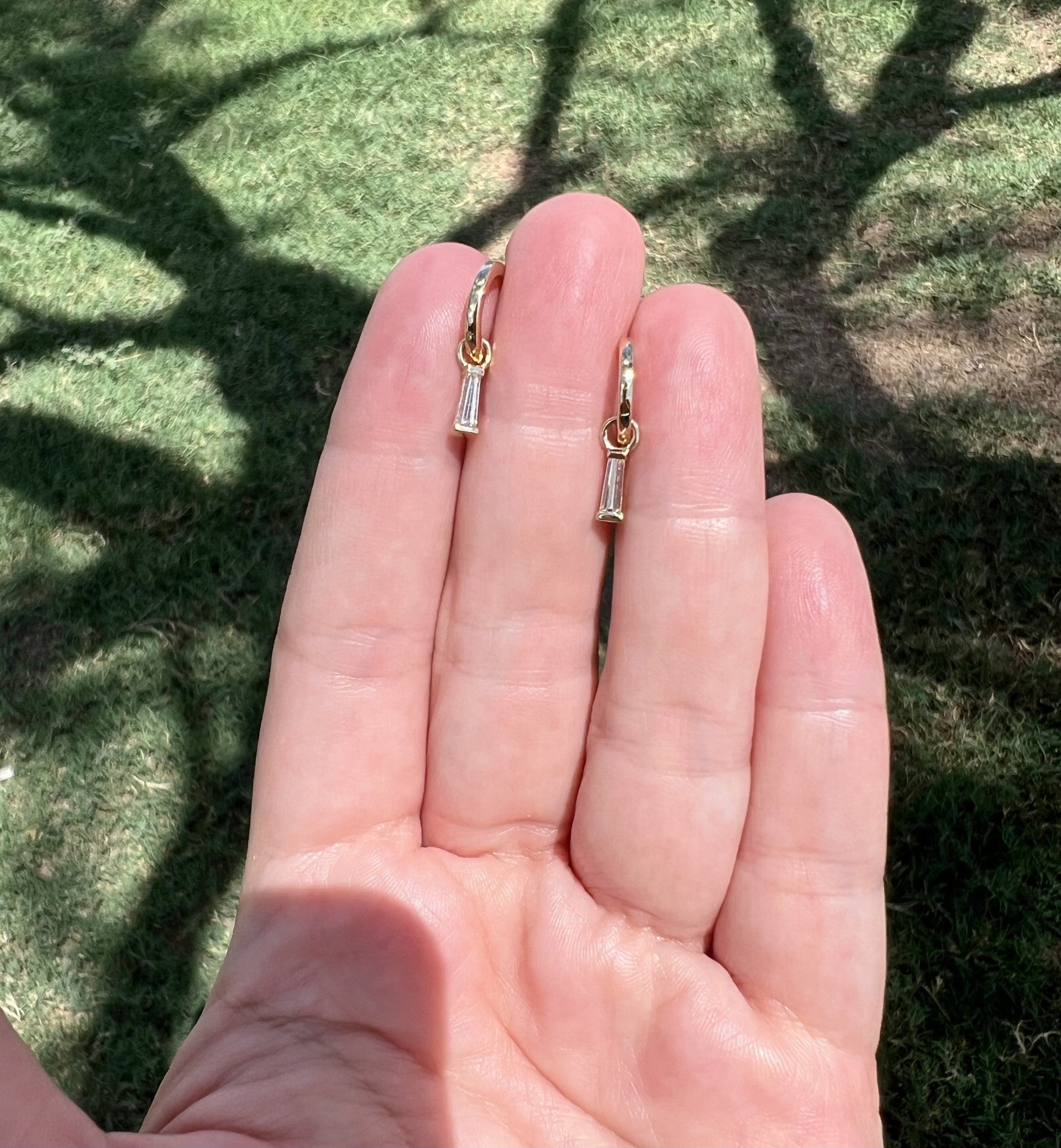 diamond tapered baguette charms hanging from 14k yellow gold huggie hoops. The diamond baguettes are removable. Allowing you to wear the earrings multiple ways.