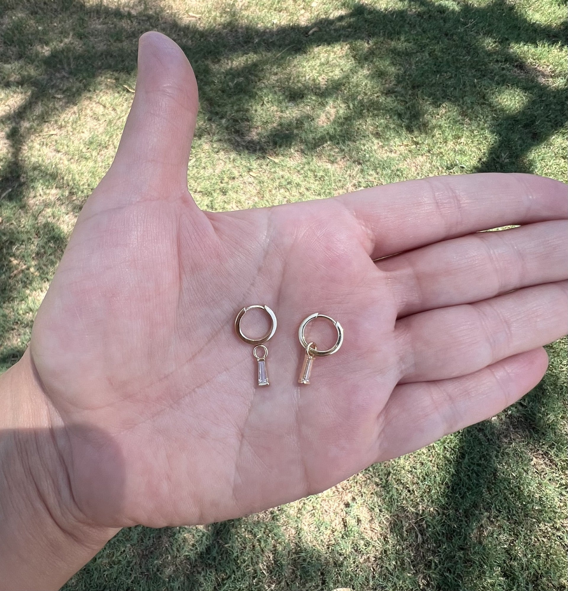 diamond tapered baguette charms hanging from 14k yellow gold huggie hoops. The diamond baguettes are removable. Allowing you to wear the earrings multiple ways.