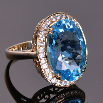 oval blue topaz ring with white sapphire halo in yellow gold