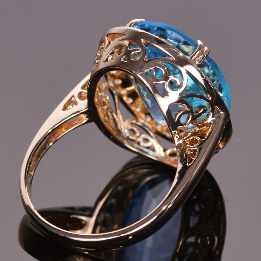 oval blue topaz ring with white sapphire halo in yellow gold