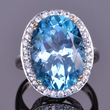 oval blue topaz ring with white sapphire halo in white gold