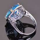 oval blue topaz ring with white sapphire halo in white gold