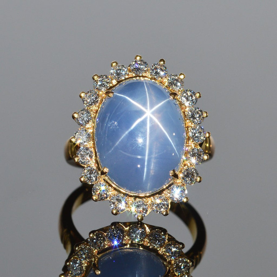 Cabochon star sapphire ring with diamond halo 